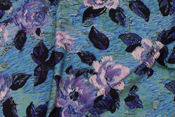 Blue-turqoise cotton-jersey with ca. 7-9 cm purple flowers