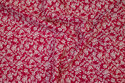 Red, firm cotton with off white flowers