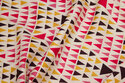 Soft, creme-colored viscose mousselin with small pink triangles