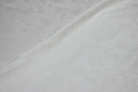 Off white jacquard-woven shiny polyestersatin with paisley-pattern