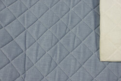 Rugged quilt in light denim-blue with thin skum back