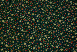 Christmas-cotton in flamed dark green with small stars in red and gold