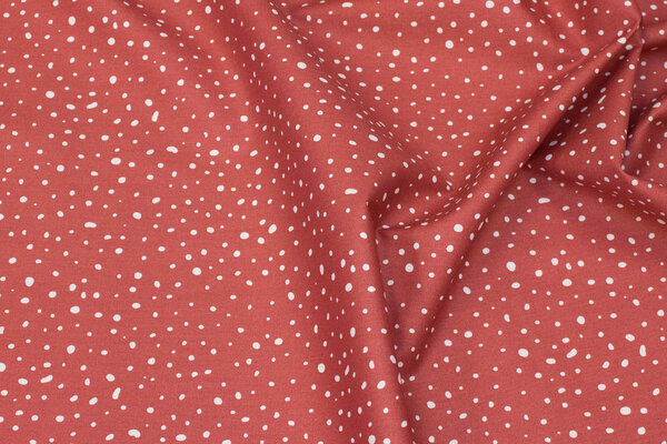 Organic cotton in brick-red with white dots